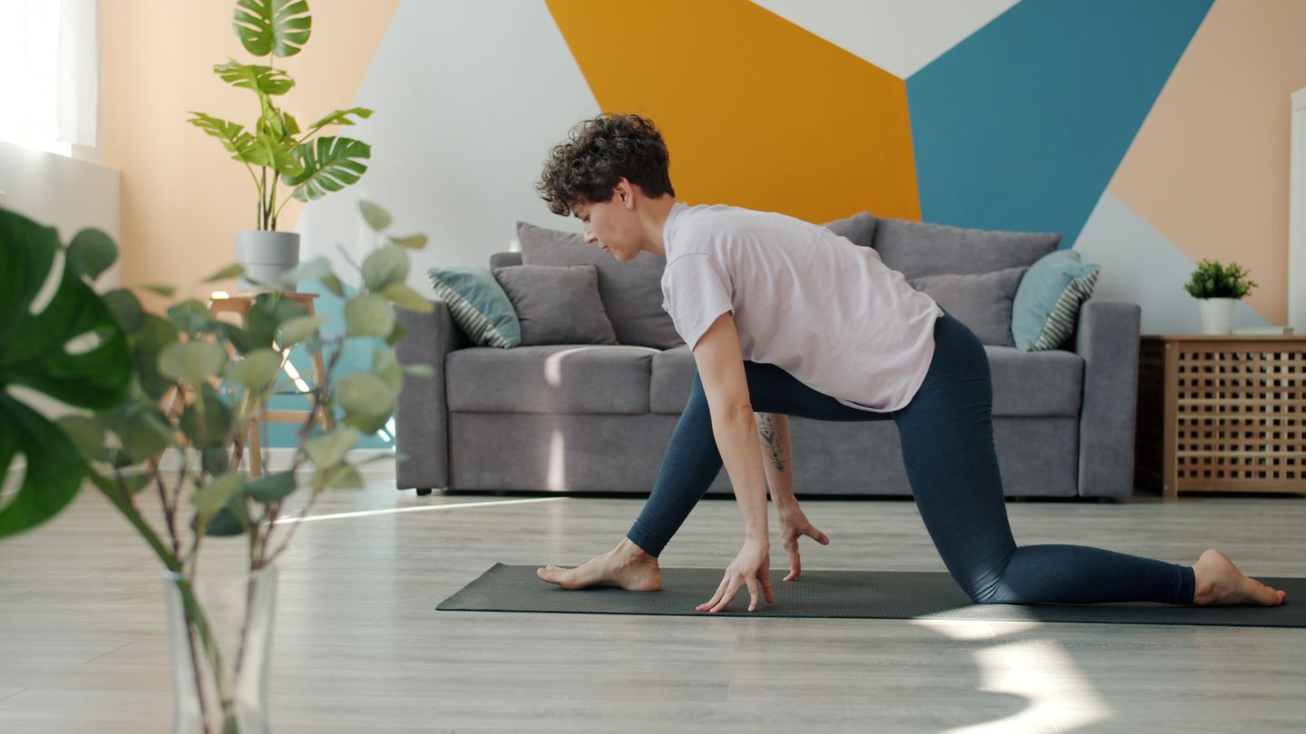 A person practicing yoga indoors with a stylish geometric wall design.